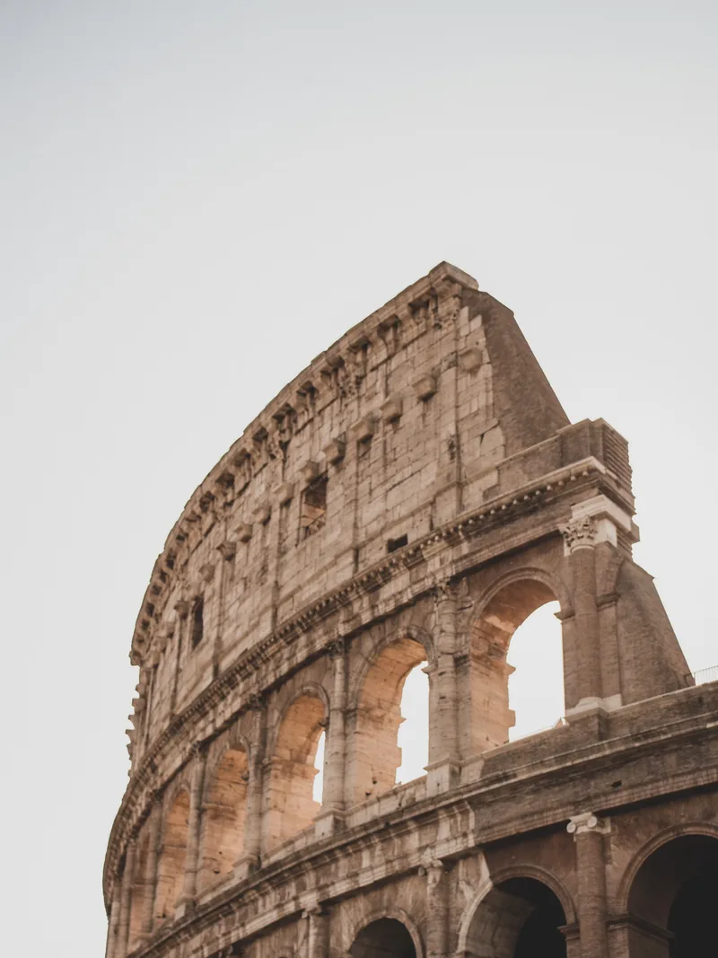 Arcos del Coliseo de Roma vistos desde abajo contra un cielo despejado